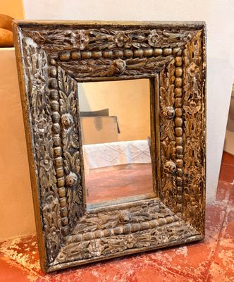 un miroir posé sur le sol à côté d'une chaise