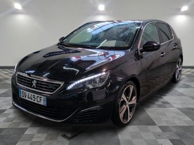 La voiture noire est garée sur le sol à damier du garage.