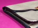 wallet on a pink background with a button on the front