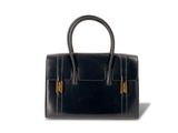 le petit sac noir est posé sur une surface blanche
