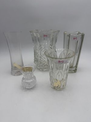 three glass vases and a glass candle holder on a white surface