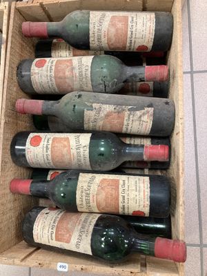 plusieurs bouteilles de vin dans une caisse en bois posée par terre
