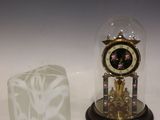 une horloge sous un dôme de verre, à côté d'un bloc de glace