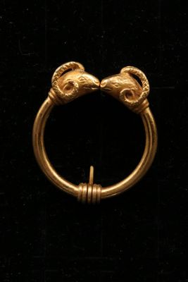 un gros plan d'une bague en or ornée de deux crânes