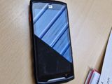 un téléphone portable posé sur une table, à côté d'une pile de papiers