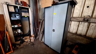 une armoire métallique dans un garage, dont la porte est ouverte