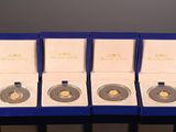 four gold coins are in a blue box on a table