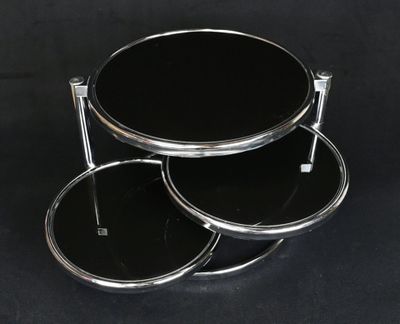 table en verre noir à trois niveaux avec des pieds chromés, sur fond noir