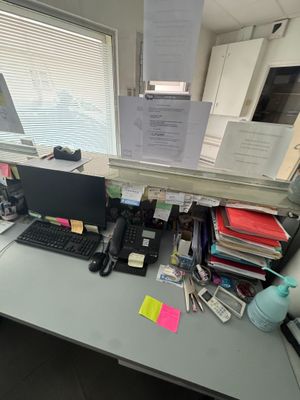 a desk with a computer, keyboard, mouse, and papers on it