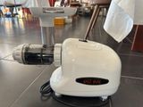 a white meat grinder sitting on the floor in a restaurant