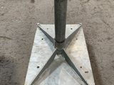 a metal pole that is on the ground in a parking lot