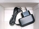 a black charger in a white box with a black cord