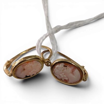 pair of pink stone earrings on a white string with a white cord