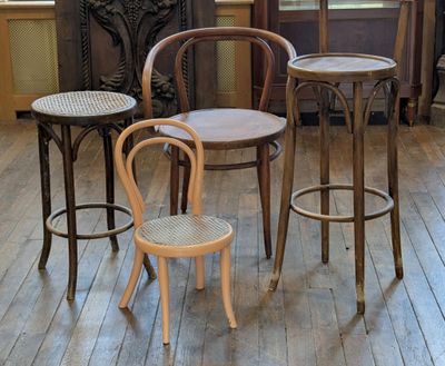 three chairs and a table in a room with wood floors