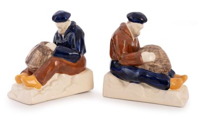 two figurines of two men sitting on a rock