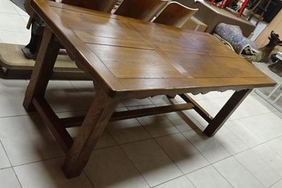 a wooden table that is sitting on a tile floor