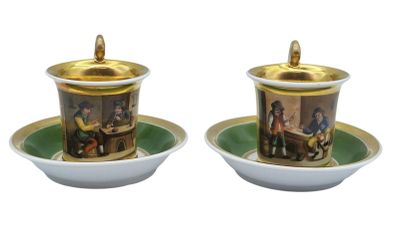 two cups and saucers with pictures of people on them