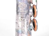 a silver saxophone that is sitting on a white surface