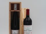 une bouteille de vin dans un coffret en bois à côté d'une bouteille de vin