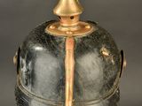 an old helmet with a gold top and a metal base
