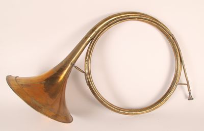 un vieil instrument en laiton muni d'un long cor, sur fond blanc