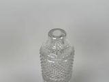 a clear glass bottle with a lid on a white surface