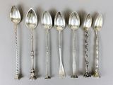 six silver spoons are lined up in a row on a table