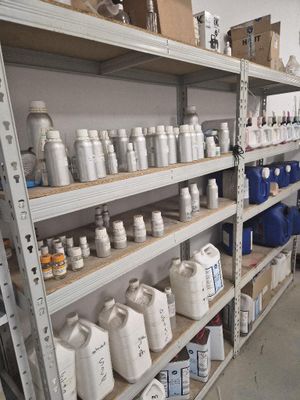 une étagère sur laquelle sont posées de nombreuses bouteilles et récipients, dans une pièce