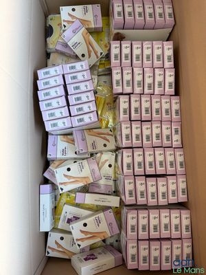 plusieurs boîtes de savon dans un carton posé par terre