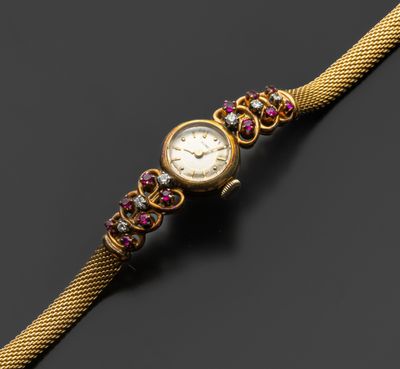 une montre en or sertie de pierres roses et vertes