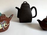 trois théières et une théière posées sur une table blanche