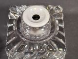 a glass candle holder with a white candle on it