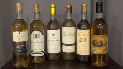 bottles of wine are lined up on a shelf in front of a wall