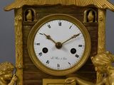 a gold clock with a statue of a man and a woman on it