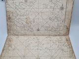 an old map of the world is open on a white surface
