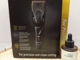 a box with a hair clipper and a bottle of hair oil