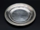 un plat ancien en argent orné d'un motif décoratif sur fond noir