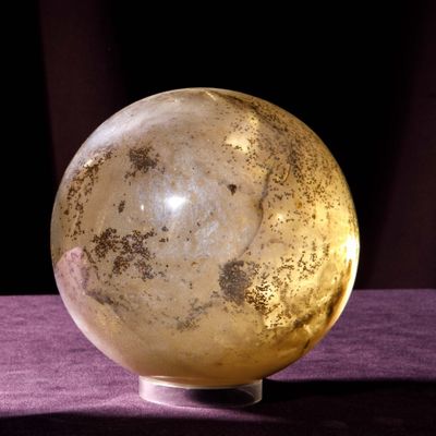 a glass ball that is sitting on a purple cloth
