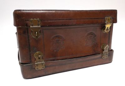 a brown leather suitcase sitting on top of a white table