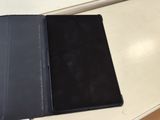 une tablette posée sur une table blanche