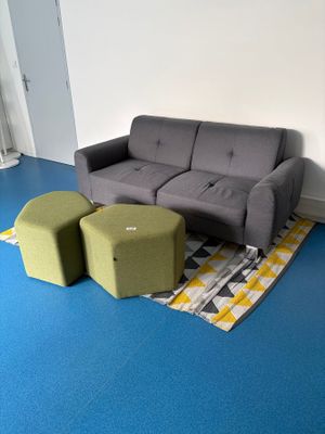 un canapé et deux tabourets dans un coin de la pièce