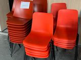 several red chairs are lined up against a wall in a room