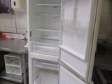 an open refrigerator in a kitchen with a tv in the background