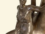 a bronze statue of a woman sitting on a horse