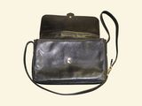 a black purse that is sitting on a white surface