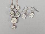 a close up of a necklace and earrings on a table