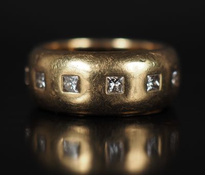 gros plan d'une bague en or avec des diamants sur une surface noire