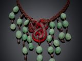a close up of a necklace with green beads on a black background
