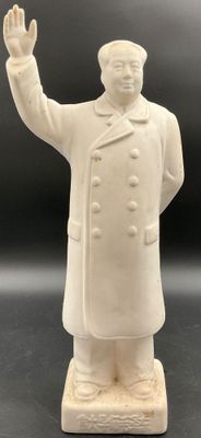 statue of a man in a white coat and hat with his hand up