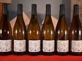 six bottles of wine are lined up in a row on a table